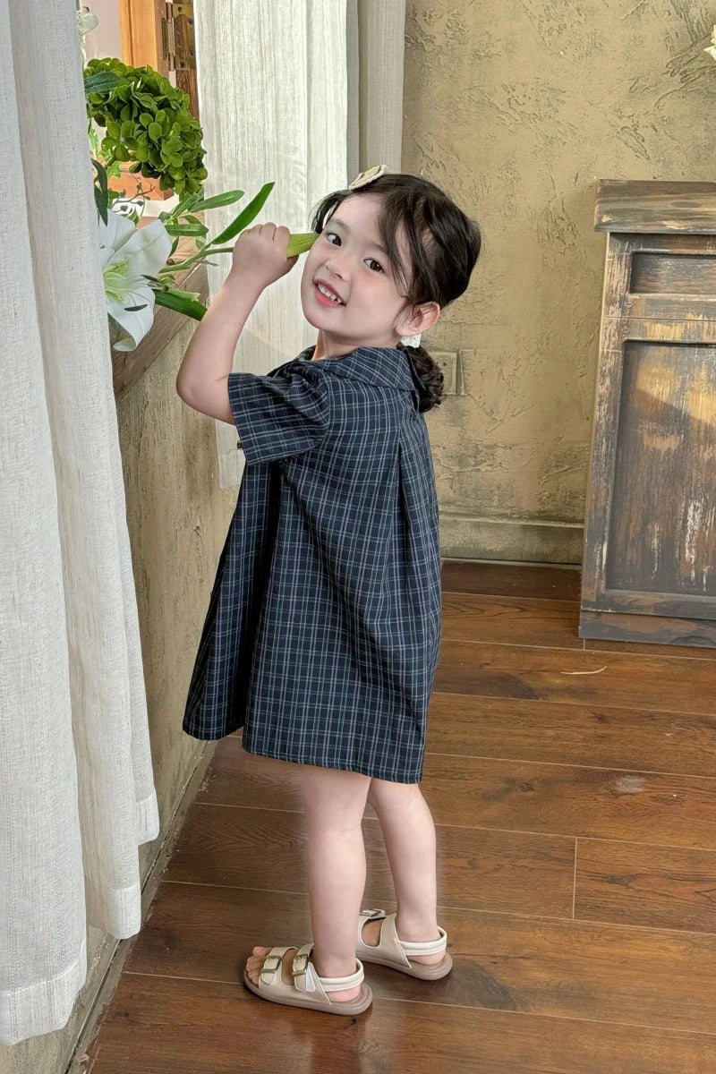 New-style fashionable girl's summer dress for little girls. A dress suitable for seaside vacations. A children's checkered dress