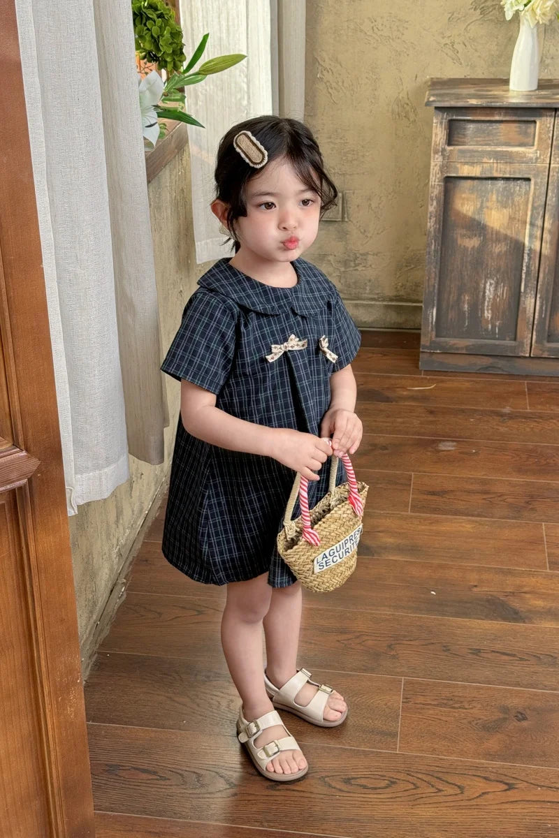 New-style fashionable girl's summer dress for little girls. A dress suitable for seaside vacations. A children's checkered dress
